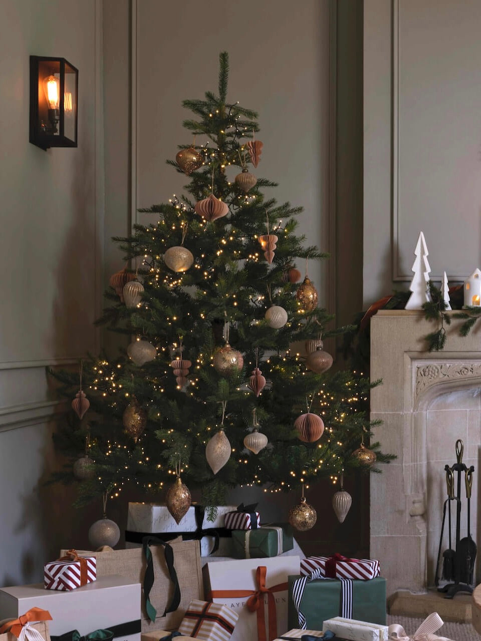 Decorated Christmas tree in a room with a fireplace and gift boxes.