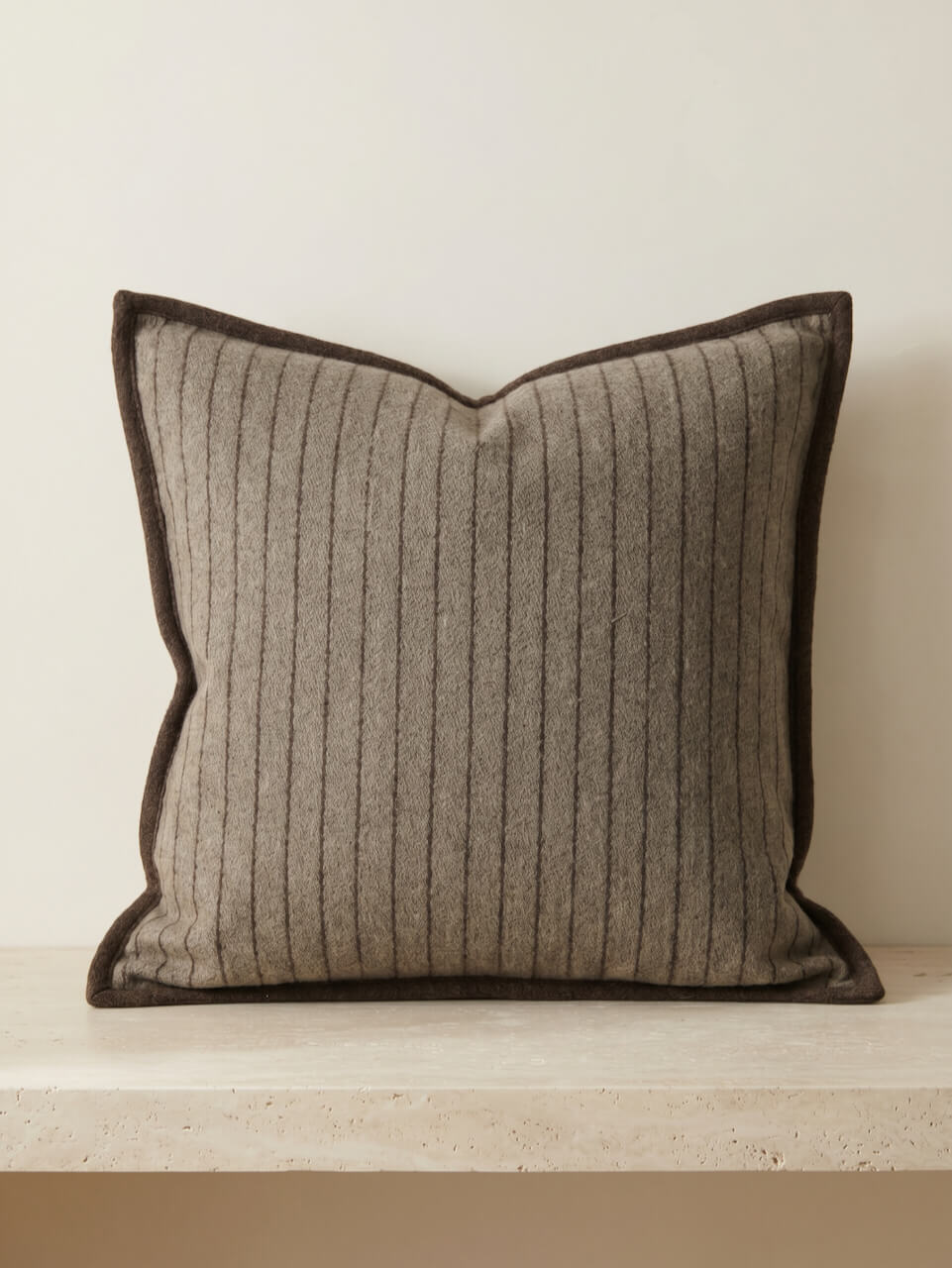 Textured pillow with striped pattern on a neutral background