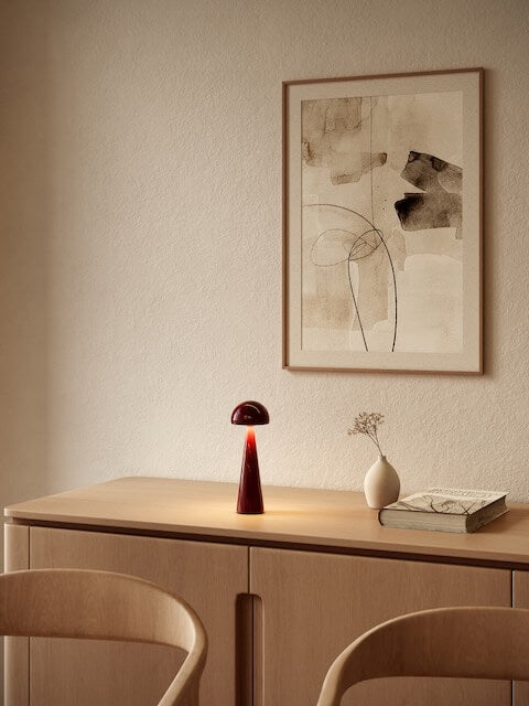 Zanzi burgundy rechargeable table lamp styled on wooden console creating soft ambient lighting cordless lamp in modern neutral interior