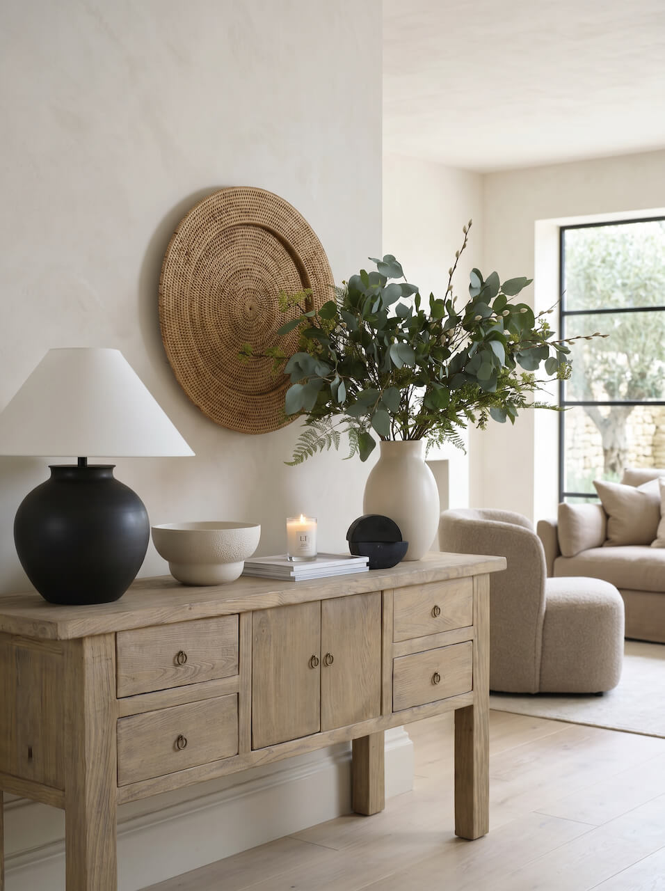 Living room with wooden sideboard, lamp, and decorative items.
