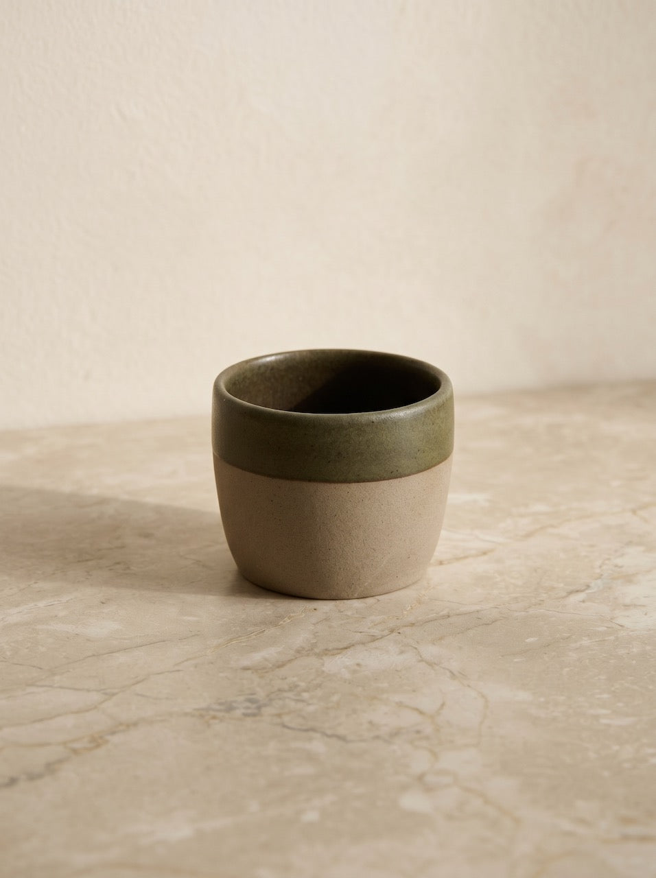 Ceramic cup with two-tone design on a textured surface