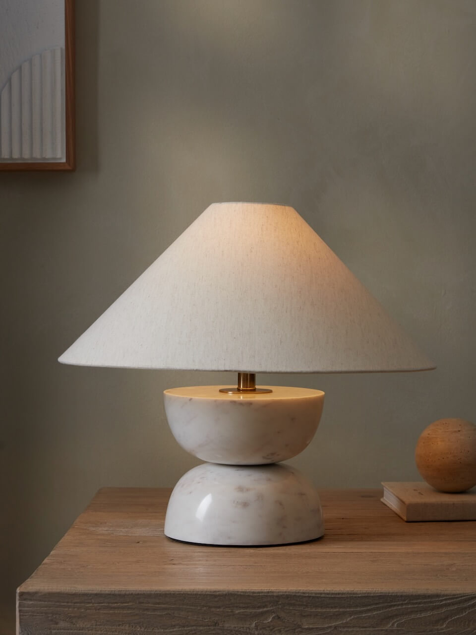 White Carrara Table Lamp with curved edges and a white cone shaped shade on a reclaimed wooden table 