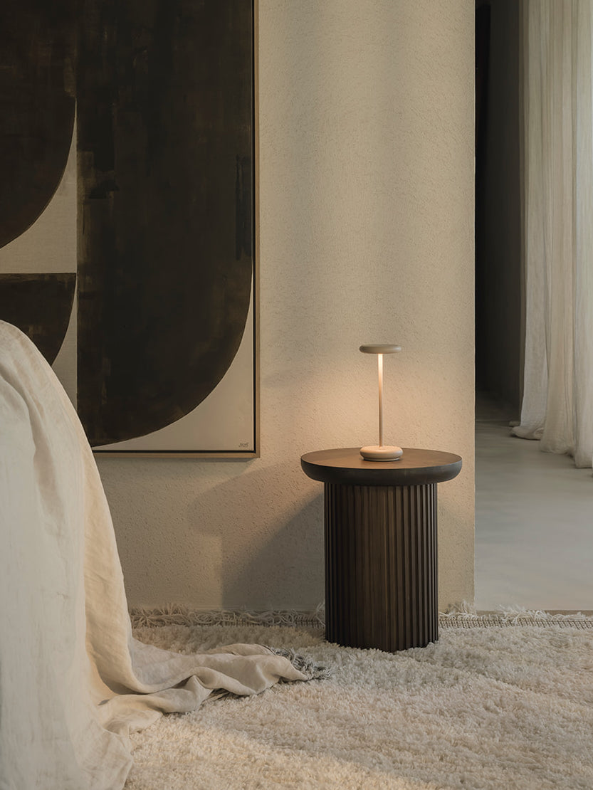 Lana cordless rechargeable table lamp in sand styled on bedside table creating soft warm lighting in neutral bedroom interior