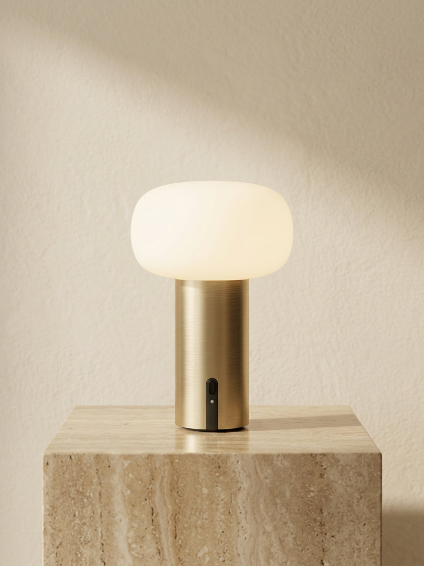 Elba rechargeable table lamp in brushed gold with mushroom design and warm dimmable light cordless bedside lamp on travertine stone plinth