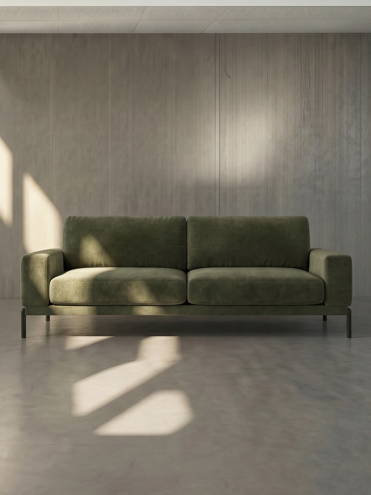 Green sofa in a minimalistic room with sunlight casting shadows on the wall.