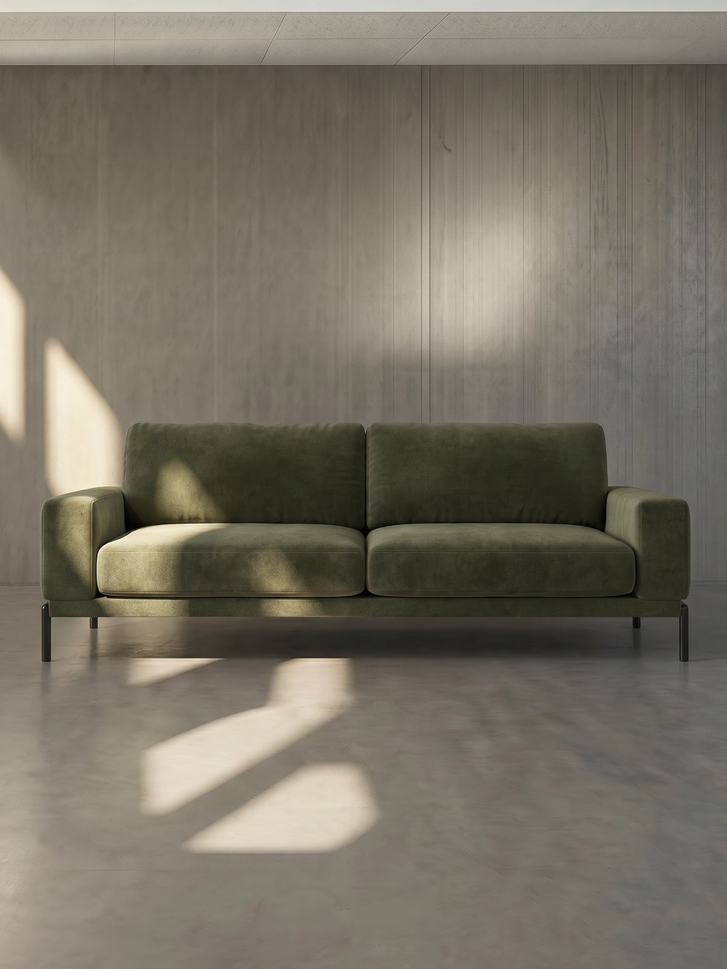 Green sofa in a minimalistic room with sunlight casting shadows on the wall.